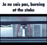 a woman is standing under a table with the words je ne sais pas burning at the stake on the bottom