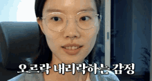 a woman wearing glasses and a nose ring is smiling in a video in korean
