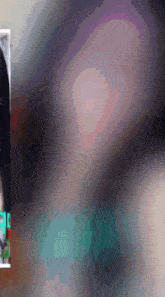 a blurred image of a woman 's face with a green sticker on it