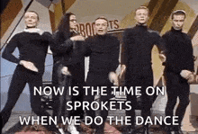 a group of people are standing next to each other and dancing in a room .