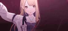 a girl with blonde hair and brown eyes is standing in a dark room .