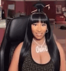 a woman with long black hair is sitting in a chair in a room .
