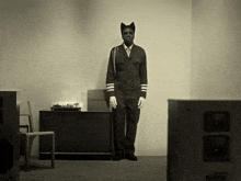 a black and white photo of a man in a cat costume standing in front of an emerson record player
