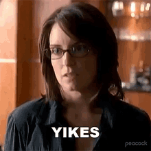 a woman wearing glasses and a black shirt is making a funny face and saying yikes .