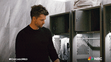 a man in a black shirt is standing in a locker room with nbc written on the bottom