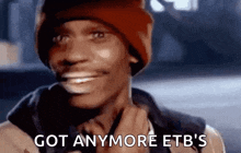 a man wearing a red beanie is smiling and says `` got anymore etb 's '' .