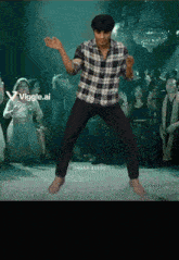 a man in a plaid shirt is dancing in front of a crowd and says vigge.ai on the bottom right