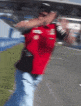 a blurry photo of a man wearing a red shirt that says ford