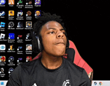 a young man wearing headphones is looking at a computer screen with a few apps on it