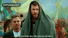 two men are standing next to each other with a blanket on their heads .