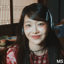 a close up of a woman wearing headphones with the letters ms on the bottom right