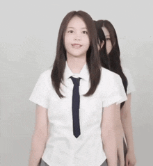 a girl in a school uniform making a heart shape with her hands .