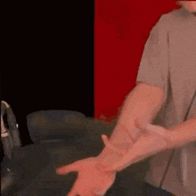 a man in a gray shirt is pointing his finger at another man .