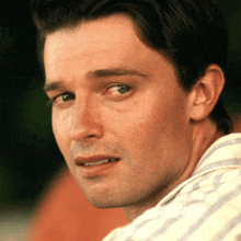 a close up of a man 's face with a smile on his face
