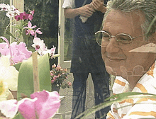 a man wearing glasses is looking at flowers in a garden