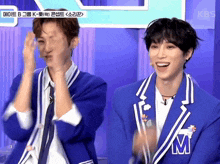 two boys in blue jackets with the letter m on their jacket