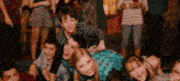 a group of young people are laying on the floor at a party and smiling .