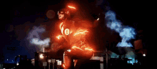 a man in a flash costume is standing on a street at night .
