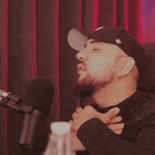 a man singing into a microphone wearing a hat that says ' ny ' on it