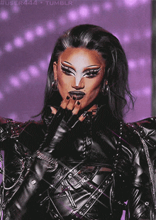 a close up of a drag queen wearing a black leather outfit