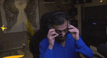 a man wearing sunglasses and headphones is sitting in front of a tv