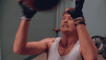 a man wearing boxing gloves is doing crunches with a medicine ball