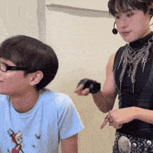 a man wearing glasses is sitting next to a woman wearing a black top