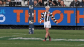 a soccer player stands on the field in front of a banner that says the oth