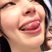 a woman is sticking her tongue out and smiling .