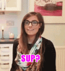 a woman wearing glasses and a scarf with the word sup written on it