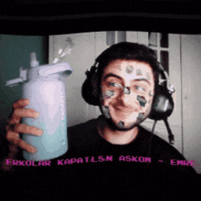 a man wearing headphones is holding a water bottle