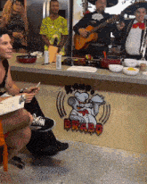 a man is playing a guitar in front of a bravo sign