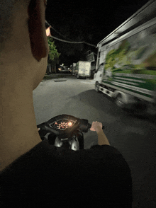 a man is riding a scooter down a street with a truck in the background