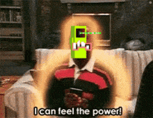 a man is sitting on a couch holding a cell phone and says " i can feel the power "