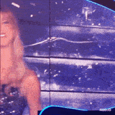 a woman is standing in front of a screen that says rbd3d on it