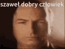 a blurred image of a man 's face with the words szczet dobry cztowiek written above him