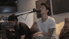 a man singing into a microphone with a black cat amplifier in the background
