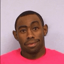 a man wearing a pink shirt is smiling for the camera .