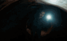a man is standing in a dark tunnel with a flashlight