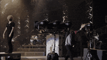 a man stands on a stage in front of a drum set with the letter k on the side