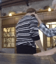 a man in a plaid shirt is putting his hand on the back of another man 's head