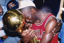 a man wearing a bulls jersey holds a trophy