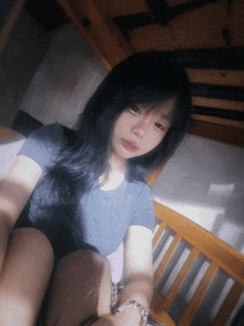 a girl with long black hair is sitting in a bunk bed