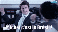 a man in a suit and tie is standing next to another man and says michel c'est le brasil