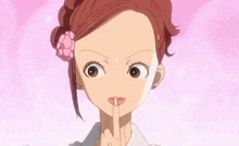 a girl with a flower in her hair holds her finger to her mouth