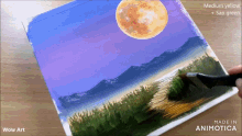 a painting of a full moon is being painted on a canvas by wow art