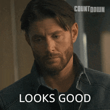 a man with a beard is wearing a denim shirt and says looks good