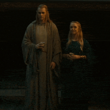 a man and a woman standing next to each other holding cups
