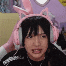 a girl wearing pink headphones and a shirt that says ecko unltd