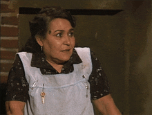 a woman wearing a blue apron has two keys in her pocket